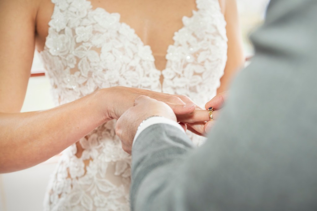 Groom placing a wedding ring on the bride’s finger during an intimate Danish wedding ceremony.