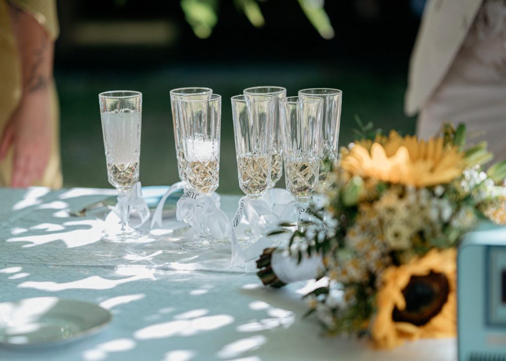 Champagne glasses prepared for a wedding toast at an outdoor celebration in Denmark.